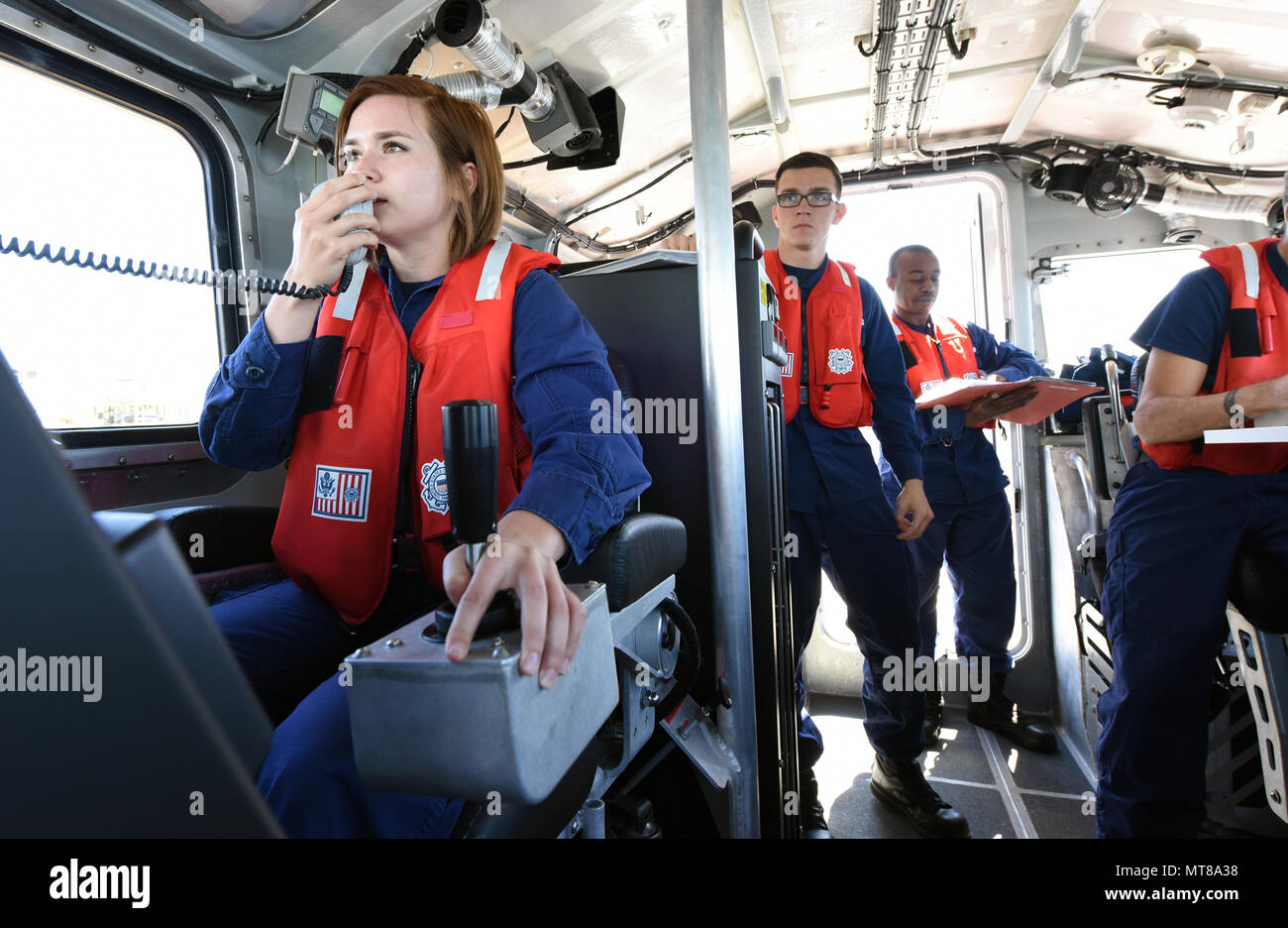 Coast Guard Petty Officer 3rd Class Sarah Welvaert, a boatswain’s mate at Station Emerald Isle, North Carolina, communicates with the station’s watchstander while piloting a 45-foot Response Boat-Medium in Bogue Inlet, March 27, 2017. Welvaert performed a wide range of piloting skills and directed her crew while under scrutiny during her coxswain certification check ride. (U.S. Coast Guard photo by Petty Officer 3rd Class Corinne Zilnicki/Released) Stock Photo