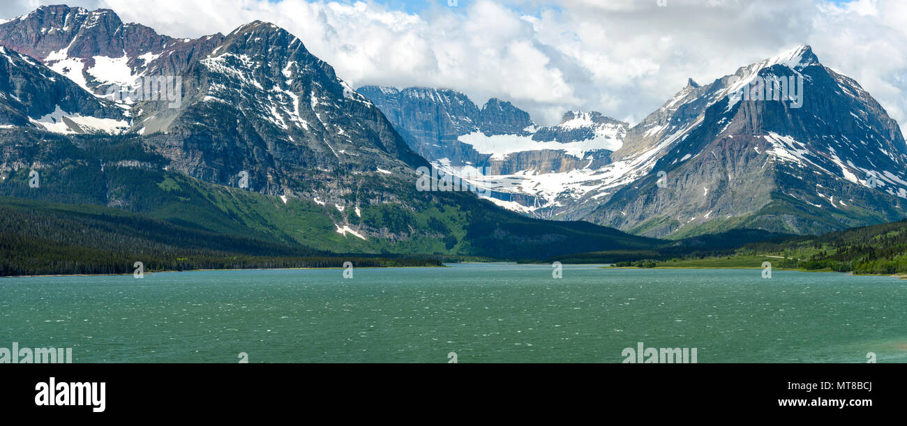 Spring at Lake Sherburne - A spring view of high mountains at Lake Sherburne in Many Glacier region of Glacier National Park, Montana, USA. Stock Photo