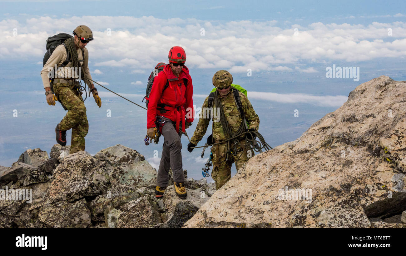 Green Berets assigned to 1st Special Forces Command navigate a ridgeline on Ellingwood Point in Alamosa County, Colorado with an instructor during the alpine portion of the Senior Mountaineer Course July 31st, 2017. The course is designed to build mountaineers capable of leading special operations missions in mountainous terrain. (U.S. Army photo by Staff Sgt. Will Reinier) Stock Photo