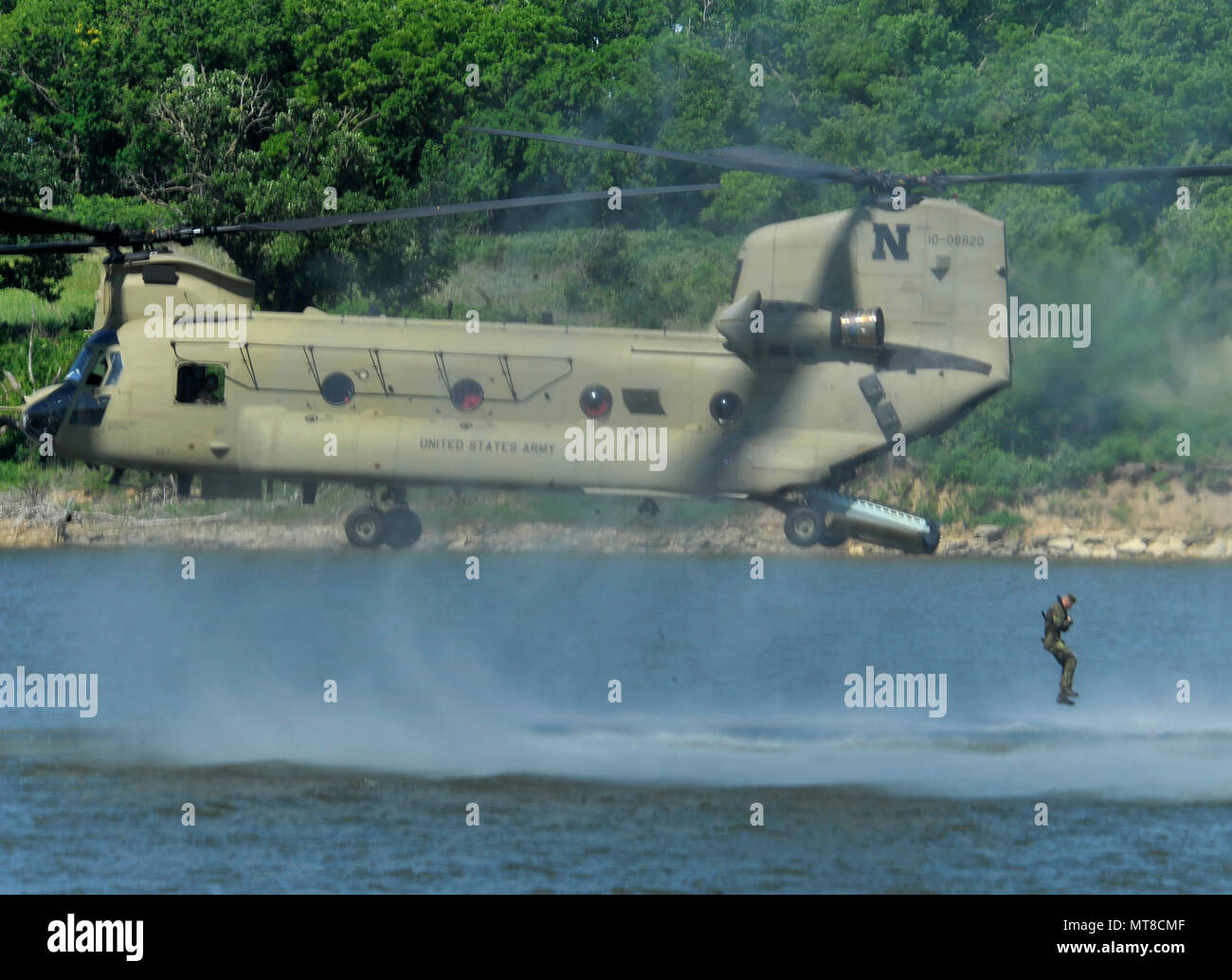 A member of the Czech Armed Forces' 7th Mechanical Brigade takes to the air while participating in a helocast waterdrop into Milford Lake near Fort Riley, Kan., June 9, with members of the Nebraska Army National Guard's 1-134th Cavalry. The exercise, which involved dropping from a Nebraska Army National Guard CH-47 Chinook helicopter and then swimming to a rubber raft, involved a total of 26 Soldiers from the Czech Republic who were training with the Nebraska cavalry Soldiers at Fort Riley. Stock Photo