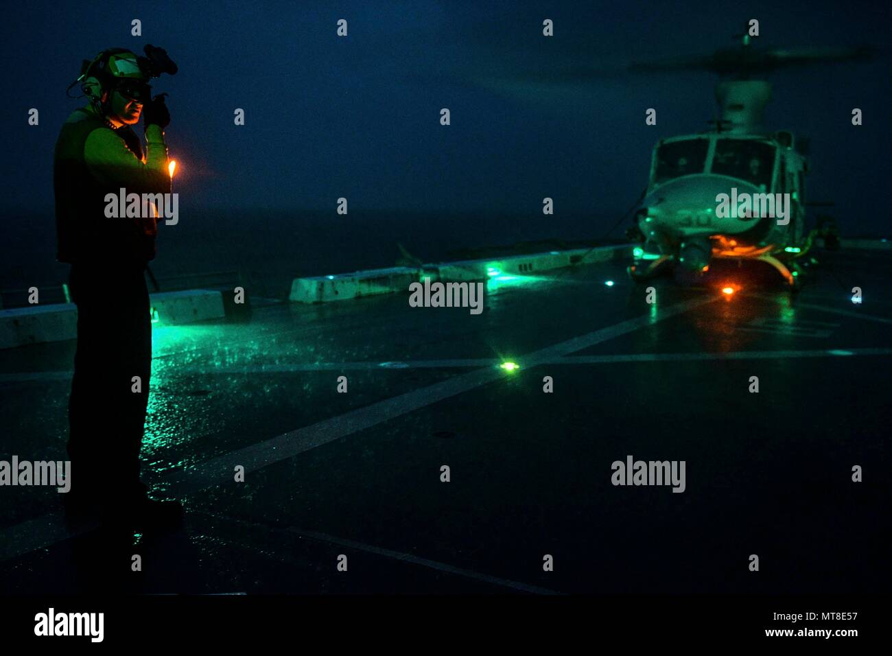 INDIAN OCEAN (Dec. 30, 2017) Aviation Boatswain Mate Handling Airman Ryan Sharland, from Newport Beach, Calif., directs A UH-1Y Venom, assigned to Marine Medium Tiltrotor Squadron (VMM) 161 (reinforced), on the flight deck of the amphibious transport dock ship USS San Diego (LPD 22). San Diego, part of the America Amphibious Ready Group, with embarked 15th MEU, is operating in the Indo-Asia-Pacificregion to strengthen partnerships and serve as a ready-response force for any type of contingency. (U.S. Navy photo by Mass Communication Specialist 3rd Class Justin A. Schoenberger/Released) Stock Photo