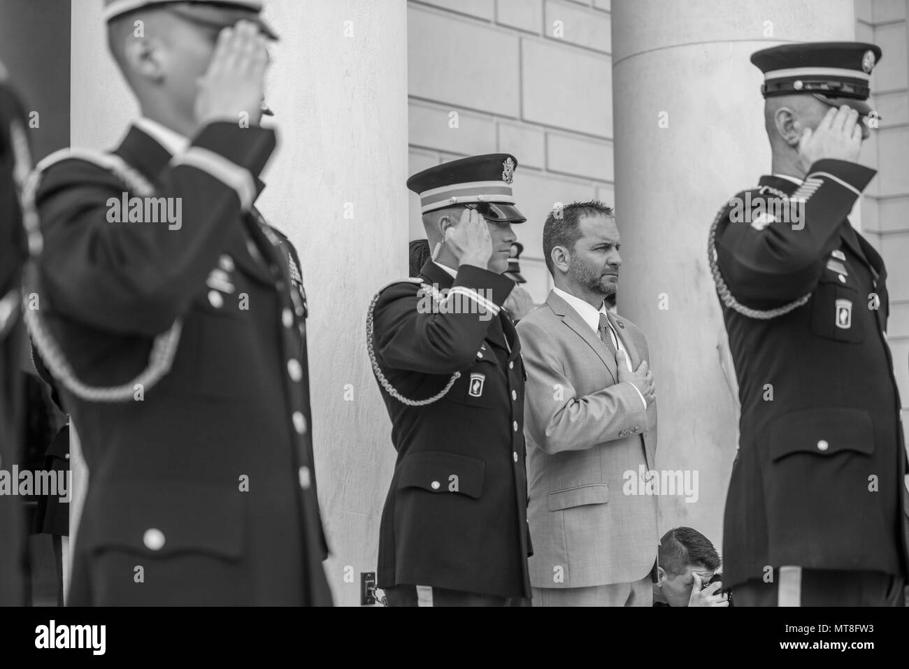 Micheal Migliara (center right), director of events and ceremonies, Arlington National Cemetery; renders honors during the playing of Taps at the Tomb of the Unknown Soldier at Arlington National Cemetery, Arlington, Virginia, May 11, 2018. (U.S. Army photo by Elizabeth Fraser / Arlington National Cemetery/ released) (This image was created in color and changed to black-and-white) Stock Photo