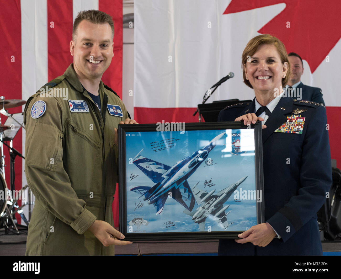 Royal Canadian Air Force Capt. Stephan Porteus presents Gen. Lori J. Robinson, commander of North American Aerospace Defense Command and U.S. Northern Command, with a lithograph at the NORAD 60th Anniversary Ceremony on Peterson Air Force Base Colorado, May 12, 2018. The ceremony and static display of various NORAD aircraft was the culmination of a three-day event, which included a media tour of Cheyenne Mountain Air Force Station, the dedication of a cairn outside the commands' headquarters building memorializing the Canadians who have passed away while serving NORAD, and a fly over in missin Stock Photo