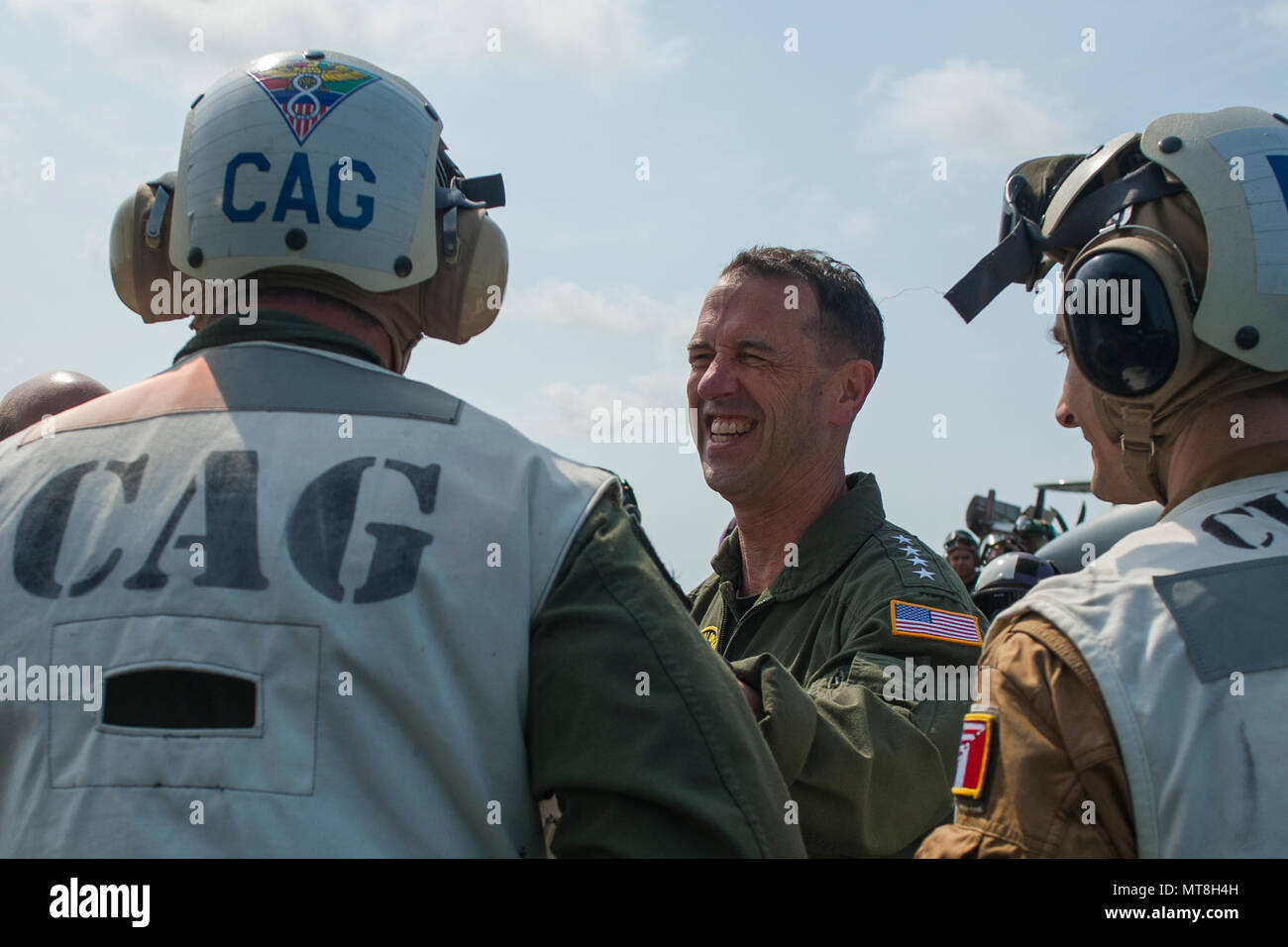 180514-N-AF077-0102 ATLANTIC OCEAN (May 14, 2018) Chief of Naval Operations (CNO) Adm. John Richardson, center, speaks with Capt. James McCall, left, commander of Carrier Air Wing (CVW) 8, and Commander Marc, commander of the French Carrier Air Wing during the CNO’s visit aboard the aircraft carrier USS George H.W. Bush (CVN 77). The ship is underway in the Atlantic Ocean conducting carrier air wing exercises with the French navy to strengthen partnerships and deepen interoperability between the two nations' naval forces. (U.S. Navy photo by Mass Communication Specialist 1st Class Sean Hurt) Stock Photo