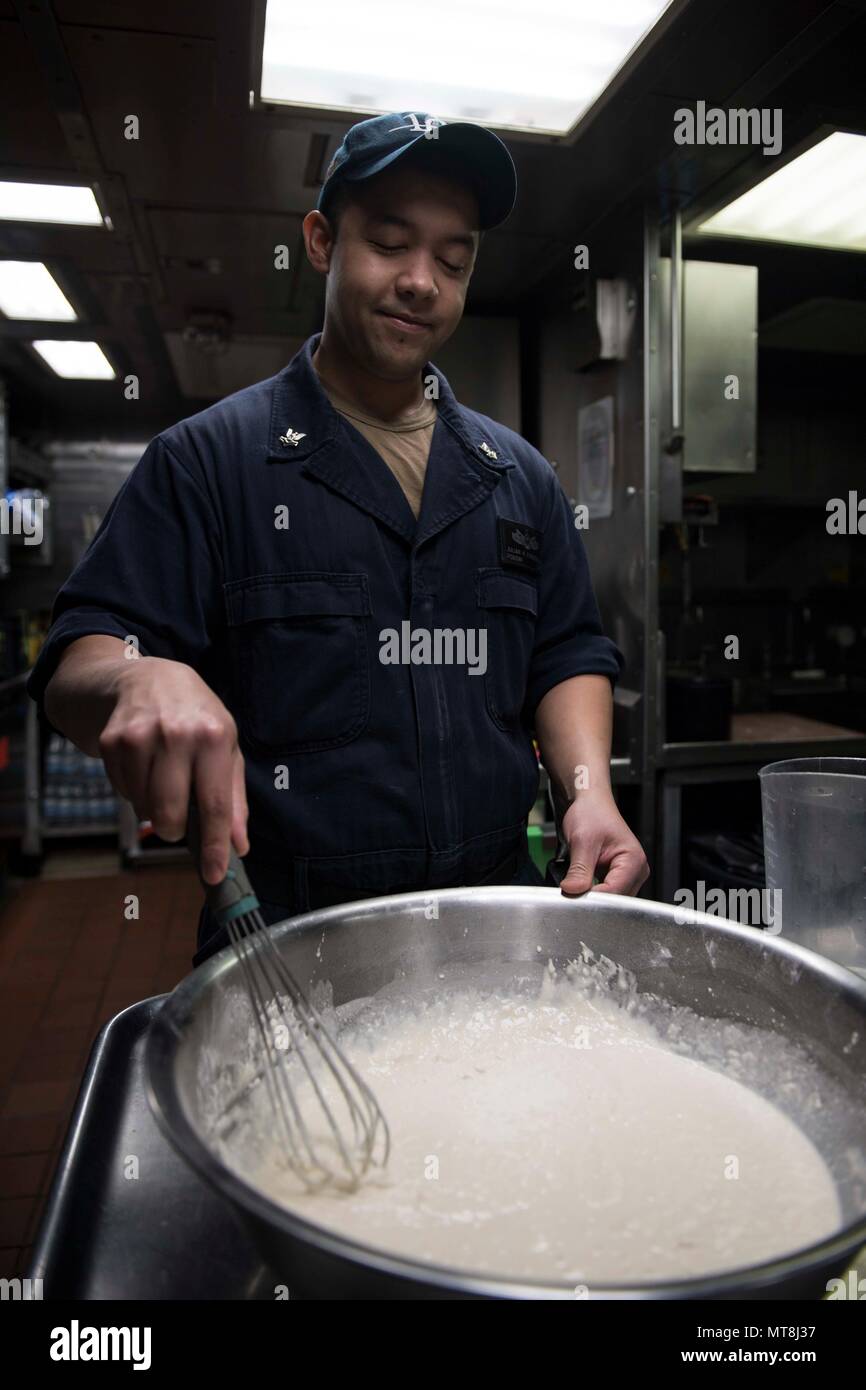 180512-N-KP946-0001 NAVAL SUPPORT ACTIVITY SOUDA BAY, Greece  (May 12, 2018) Culinary Specialist 2nd Class Julian Fuenzalida, from Houston, Texas, prepares food aboard the Arleigh Burke-class guided-missile destroyer USS Donald Cook (DDG 75), May 12, 2018. Donald Cook, forward-deployed to Rota, Spain, is on its seventh patrol in the U.S. 6th Fleet area of operations in support of regional allies and partners, and U.S. national security interests in Europe and Africa. (U.S. Navy photo by Mass Communication Specialist 2nd Class Alyssa Weeks / Released) Stock Photo