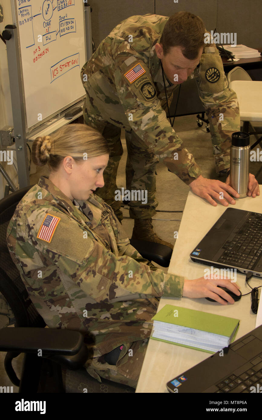 Staff. Sgt. Stephanie White, an Intelligence Non-Commissioned Officer with  the Montana National Guard shows Maj. Mike Talia, Deputy Staff Judge  Advocate, Montana National Guard a flow-chart of current events during  Cyber Shield,