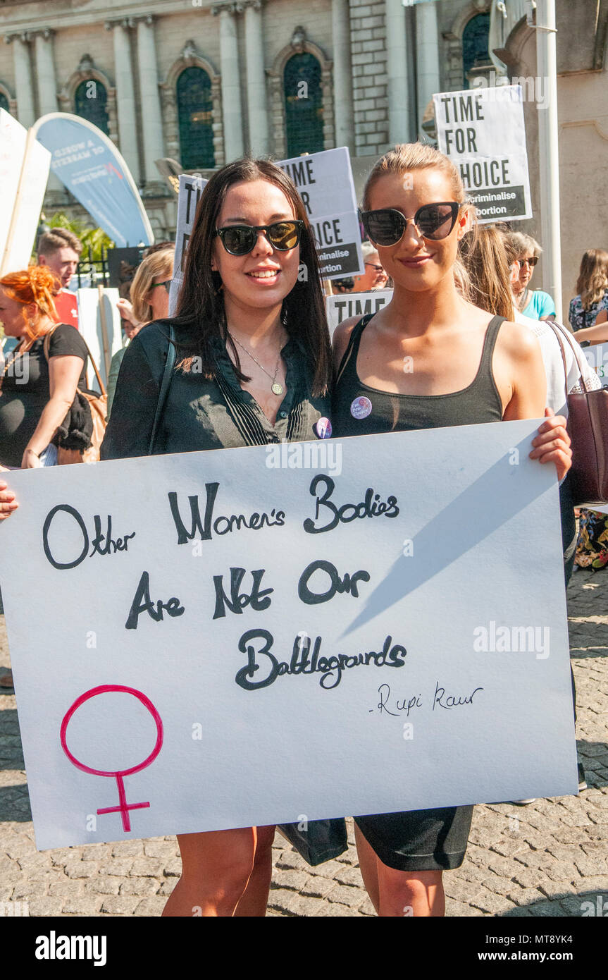 Belfast, Northern Ireland. 28/05/2018 - Two women hold a placard saying 'Other Women's bodies are not our battlegrounds', a quote by Rupi Kaur.  Around 500 people gather at Belfast City Hall to call for the decriminalisation of abortion in Northern Ireland.  It comes the day after a referendum held in the Republic of Ireland returned a substantial 'Yes' to removing the 8th amendment to the constitution, which gives equal right of life to both the mother and baby, effectively banning abortion in all circumstances. Stock Photo