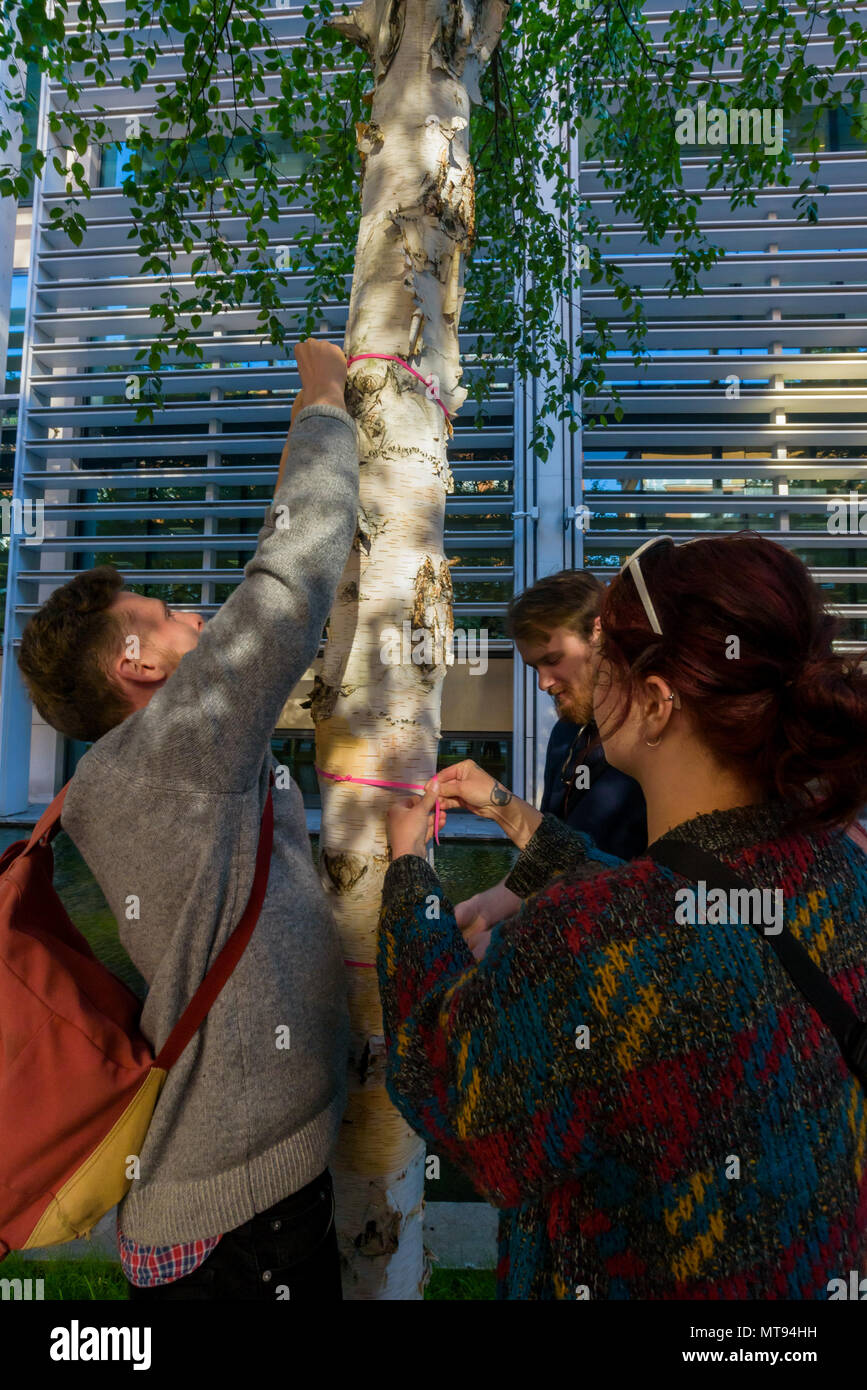 May 22, 2018 - London, UK. Protesters tie pink ribbons around the trunks of trees in front of the Home Office at the protest calling for an end to all charter flights forcibly taking migrants back to Commonwealth countries, and in particular protesting against a secretive flight expected this week to Pakistan. Many are restrained for the deportation and each accompanied by two or more security guards, and passengers and aircrew on normal services have often refused to take off with people who understandably object to being taken to countries where they may face persecution, harm, isolation or Stock Photo