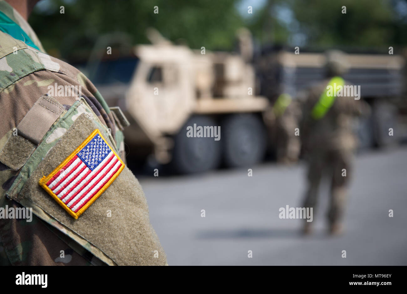 29 May 2018, Germany, Augustdorf: An American soldier, with the "stars and  stripes" sewn onto the sleeve of his uniform, standing in front of a  military vehicle. Due to the planned rotation