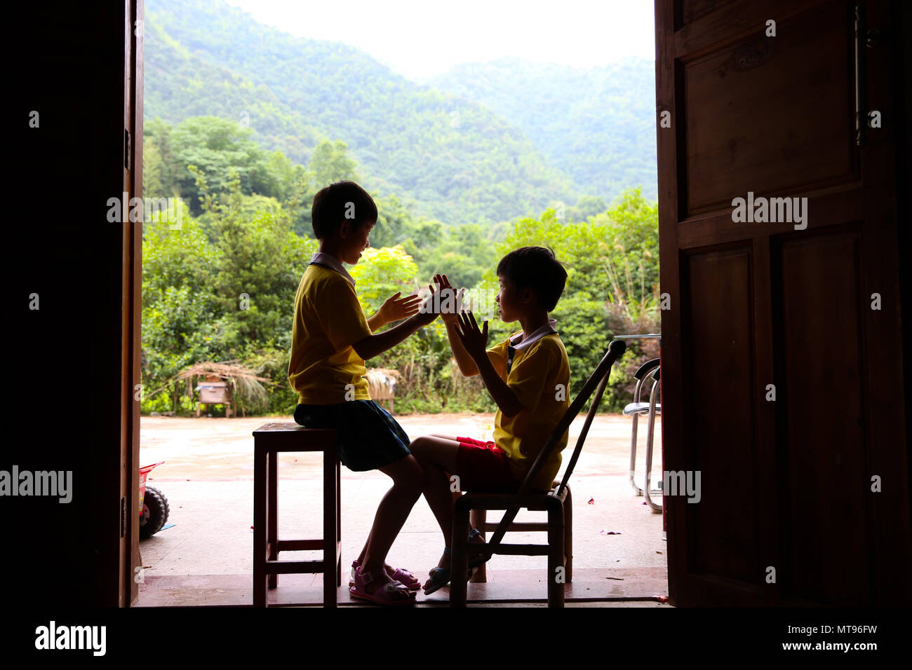 Nanchang, China's Jiangxi Province. 23rd May, 2018. Nine-year-old Zhang Xianghua (L) plays with her twin sister Zhang Xianglan in Suolong Village of Yudu County, east China's Jiangxi Province, May 23, 2018. With about 1,000 residents, Suolong Village has 29 cases of multiple births, a high rate considering the modest population size. Credit: Pan Siwei/Xinhua/Alamy Live News Stock Photo