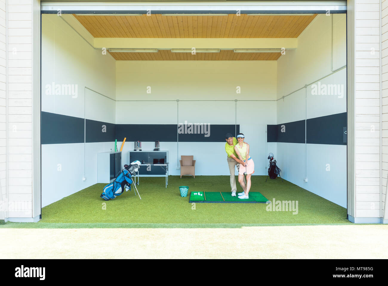 Dedicated golf coach using modern equipment while teaching a young woman Stock Photo
