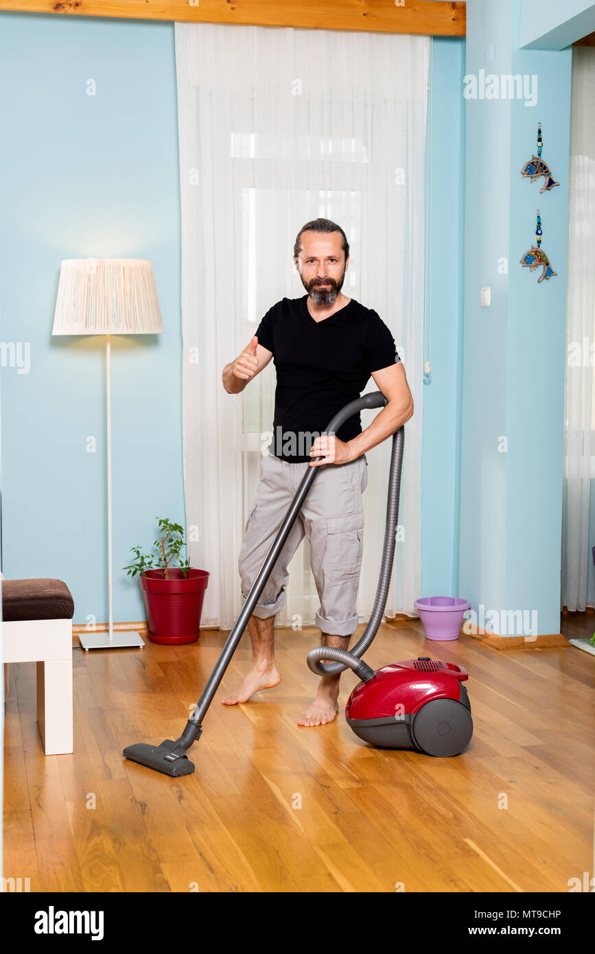 House sweeping man, sweeping wood work with broom machine Stock Photo
