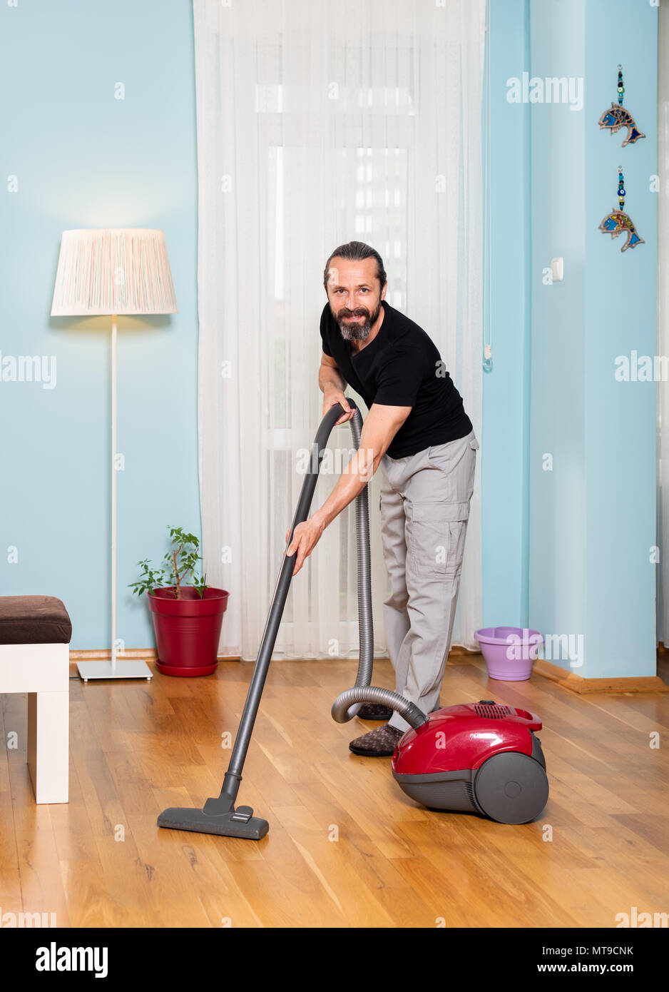 House sweeping man, sweeping wood work with broom machine Stock Photo
