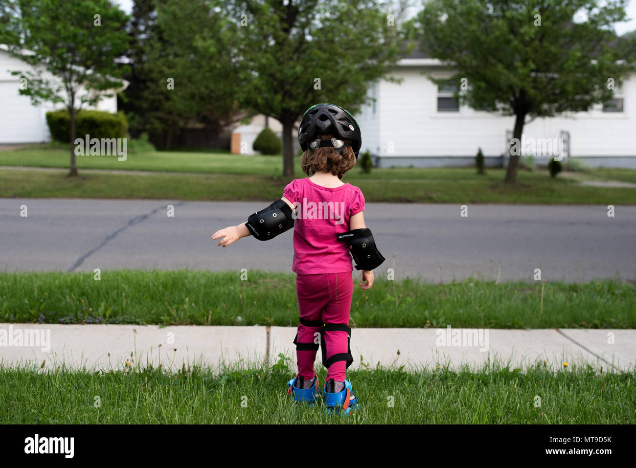 A preschool child wearing bicycle safety gear. Stock Photo