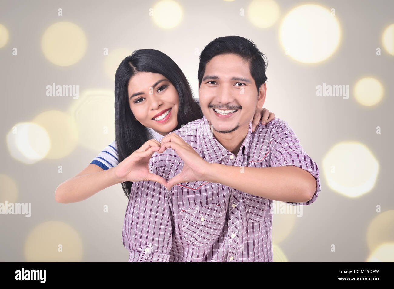 Romantic asian couple in love make a heart shape with their hands ...