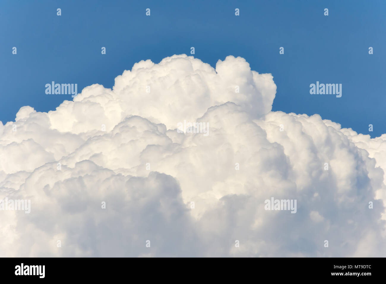 Cloudscape of fluffy white sunlit clouds Stock Photo - Alamy