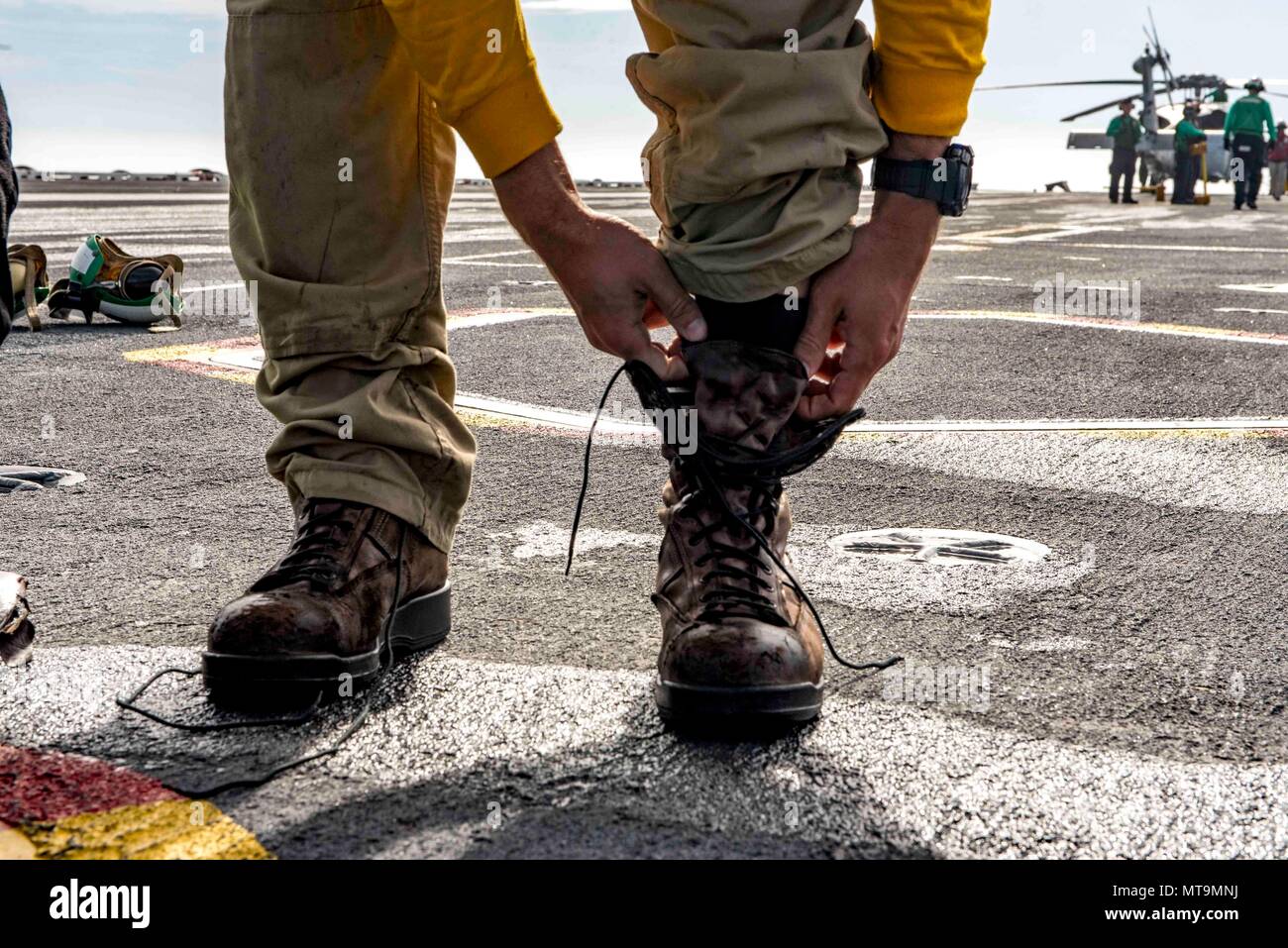 180517-N-UV609-0342 ATLANTIC OCEAN (May 17, 2018) Lt. Joshua Pritt, from  Newcastle, Delaware, removes his boots for a "boot shot" off the aircraft  carrier USS George H.W. Bush (CVN 77) to honor his