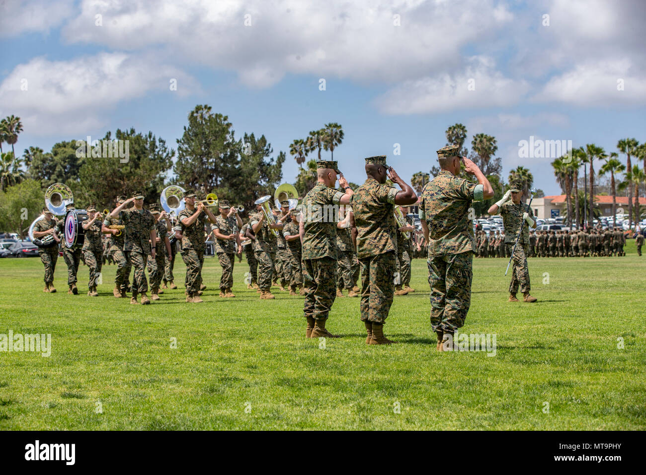 The 1st Marine Division Band marches by Sgt. Maj. Bradley Kasal, left, the outgoing I Marine Expeditionary Force sergeant major, Sgt. Maj. James Porterfield, center, the incoming I MEF sergeant major, and Lt. Gen. Lewis Craparotta, the I MEF commanding general, during a relief and appointment ceremony on Camp Pendleton, Calif., May 18, 2018. Porterfield replaced Kasal as I MEF sergeant major. Kasal has served as I MEF sergeant major since 2015 and is retiring from the Marine Corps after 34 years of service. (U.S. Marine Corps photo by Lance Cpl. Clare Mcintire) Stock Photo