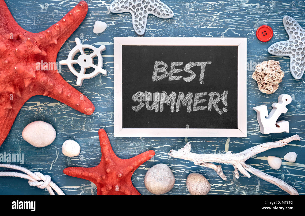 Blank blackboard with sea shells, stones, rope and star fish on blue wooden background, text 'Best summer' Stock Photo