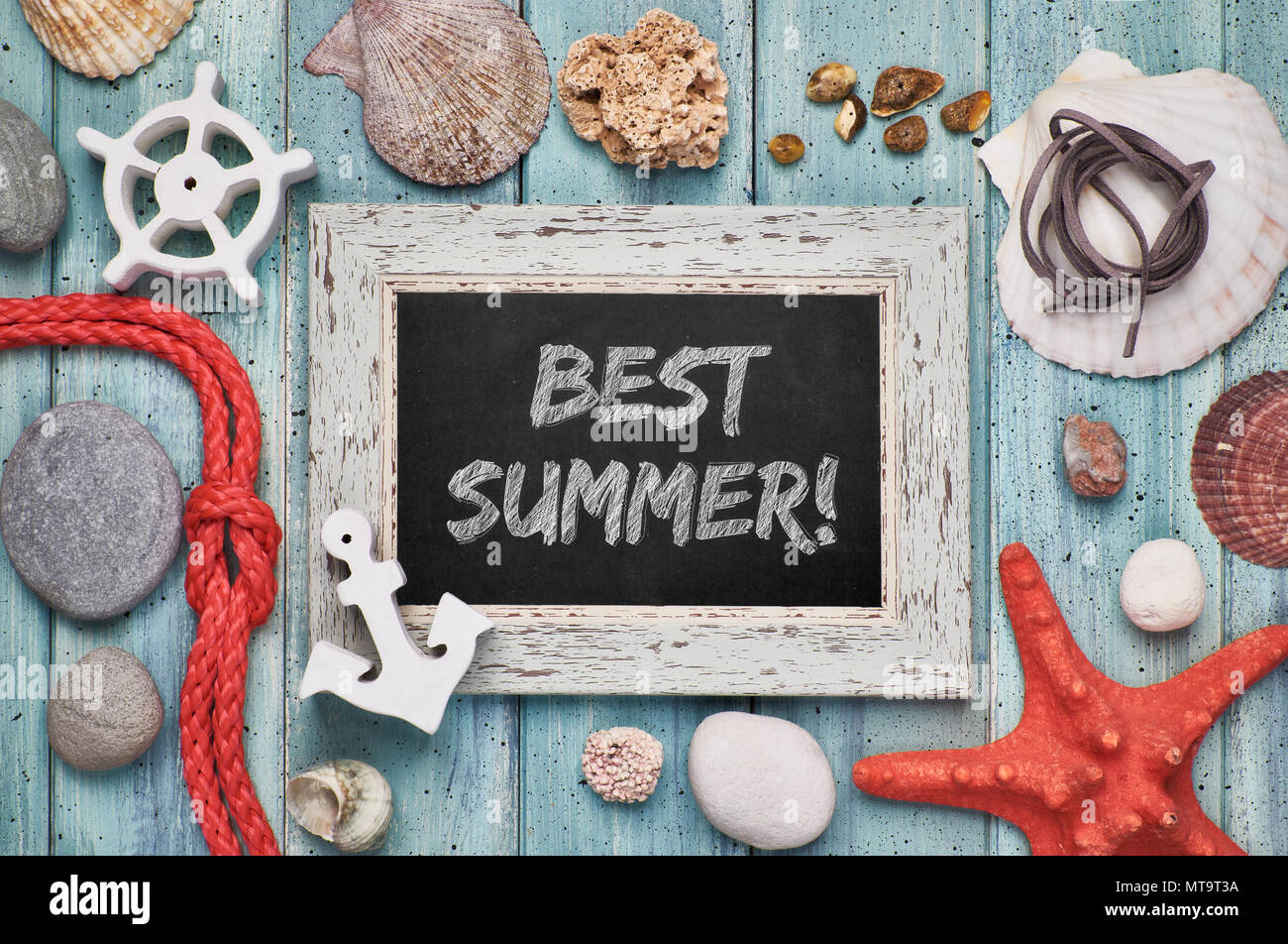 Blackboard with 'Best summer' chalk text, with sea shells, rope and star fish on light green wooden background Stock Photo