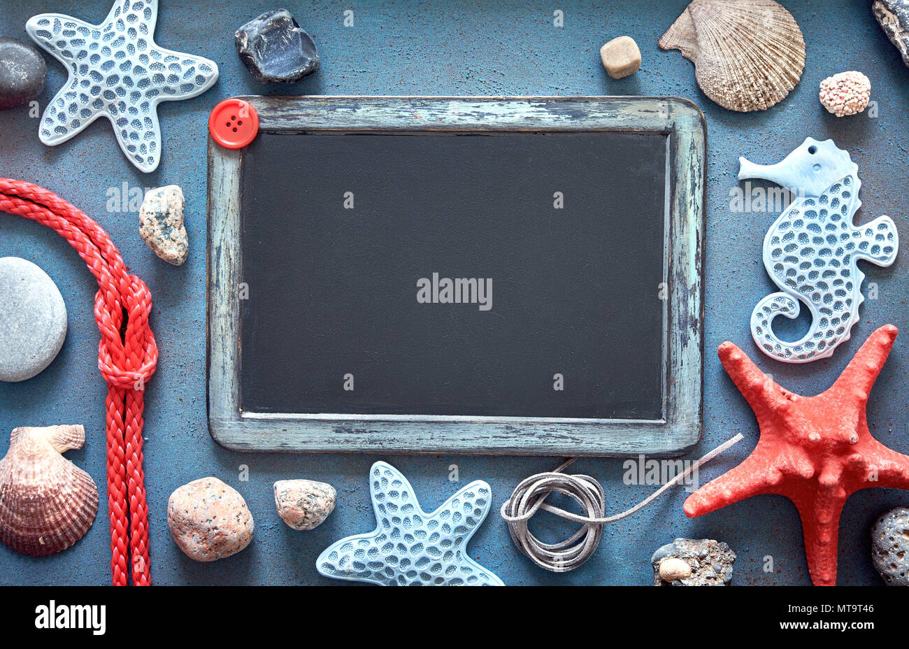 Blank blackboard with sea shells, rope and star fish on blue structured background, text space Stock Photo