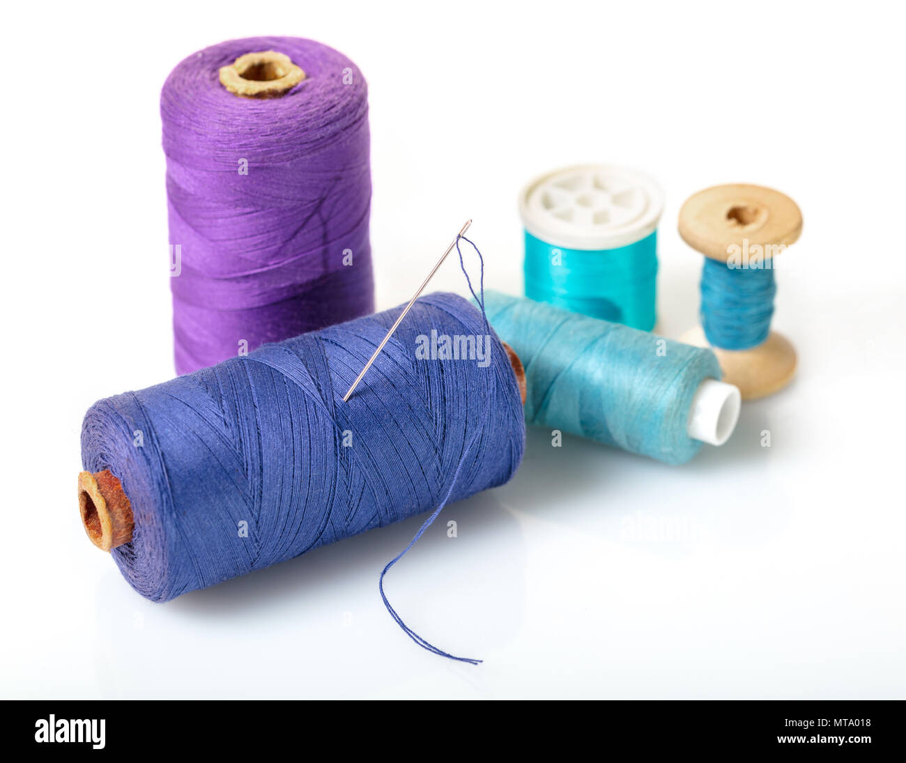 Dark green thread spool with purple crochet hook, isolated on white  background Stock Photo - Alamy