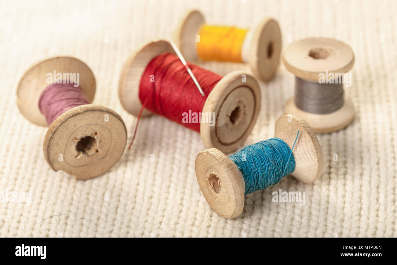 coils of colored thread on white knitted fabric Stock Photo - Alamy