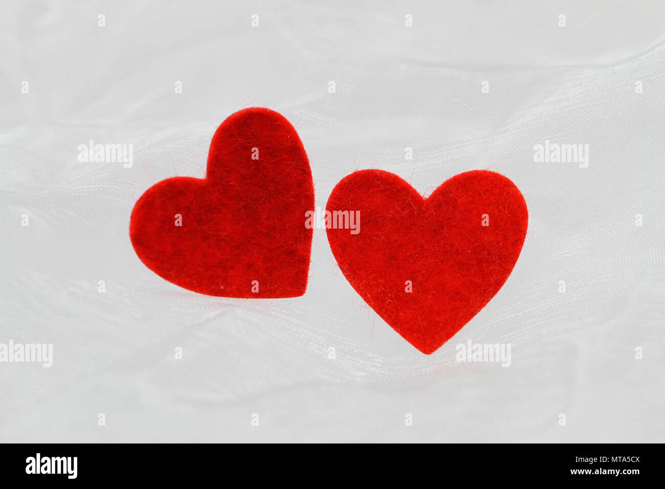 Two red hearts on white cloth with copy space Stock Photo - Alamy