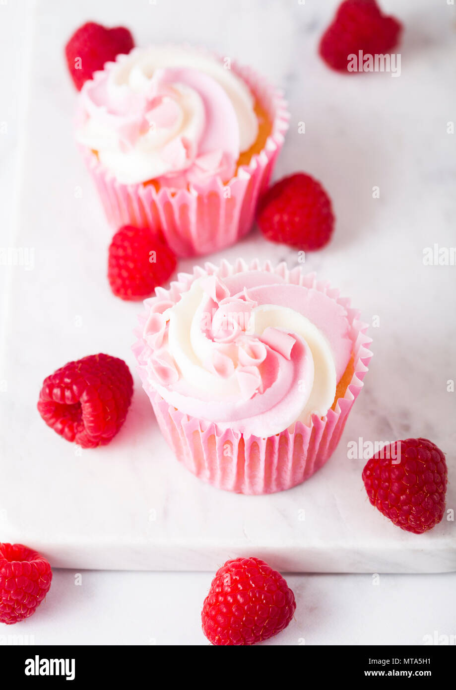 Cupcake muffin with raspberry cream dessert on marble background with freshraspberry Stock Photo