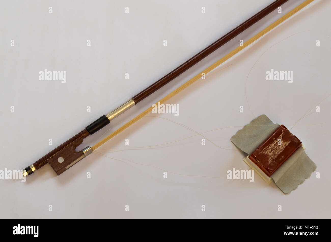 Violin bow and rosin case to apply in the bow hair. Materials for