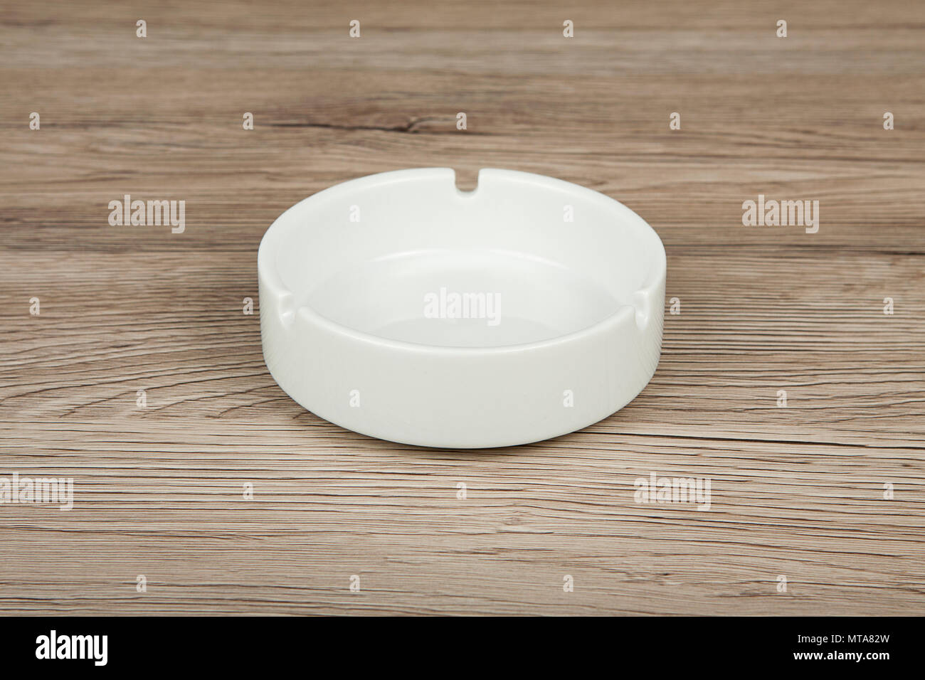 White ceramic ashtray on a wooden background Stock Photo
