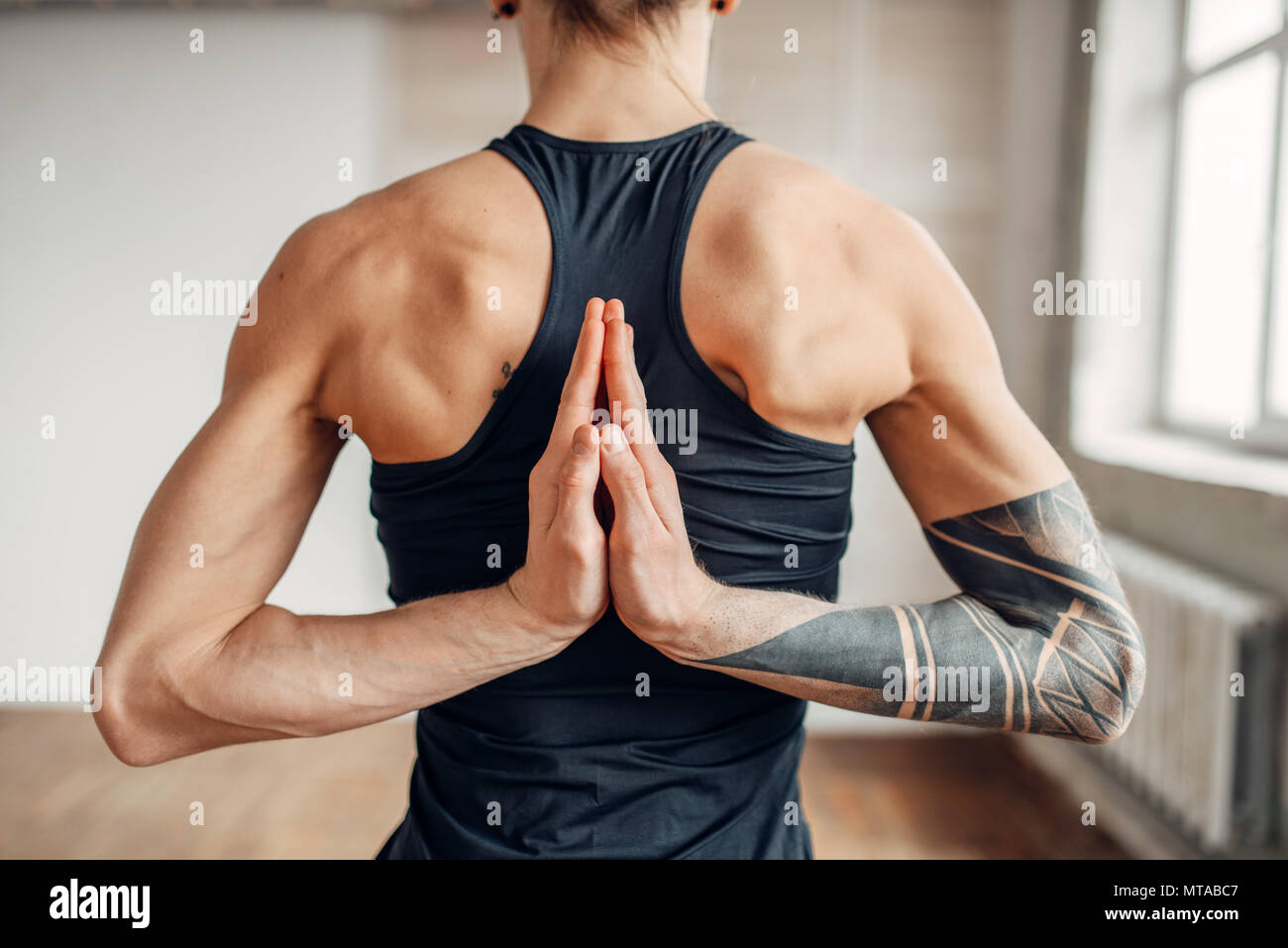 Male yoga on training, flexibility of human body. Balance exercise on mat  in gym with grunge interior. Fit workout indoors Stock Photo - Alamy