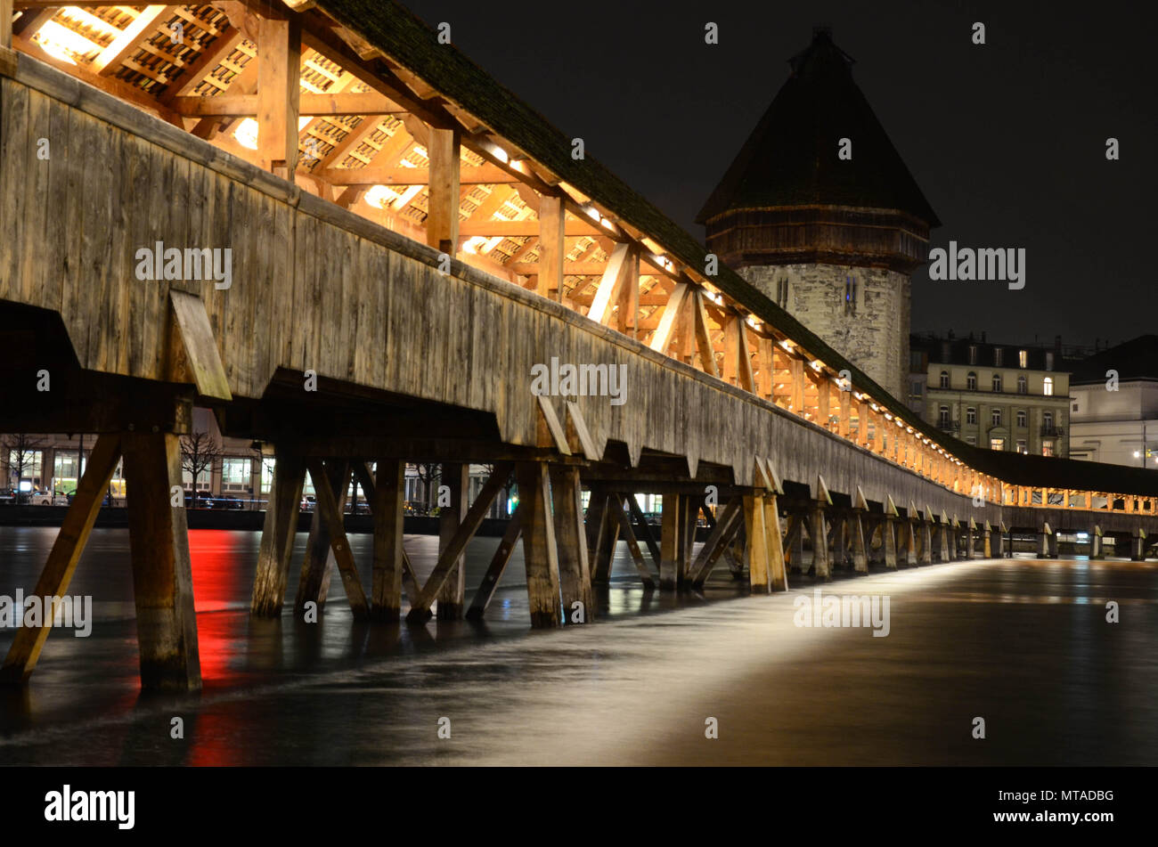 The wooden Kapellbrücke (Chapel Bridge) at night, built 1333, spanning the river Reuss (Rüüss), Lucerne (Luzern), Switzerland, January 2018 Stock Photo