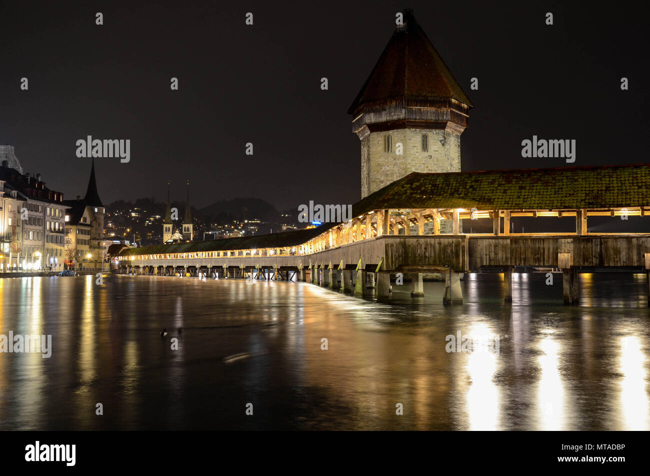 The wooden Kapellbrücke (Chapel Bridge) at night, built 1333, spanning the river Reuss (Rüüss), Lucerne (Luzern), Switzerland, January 2018 Stock Photo