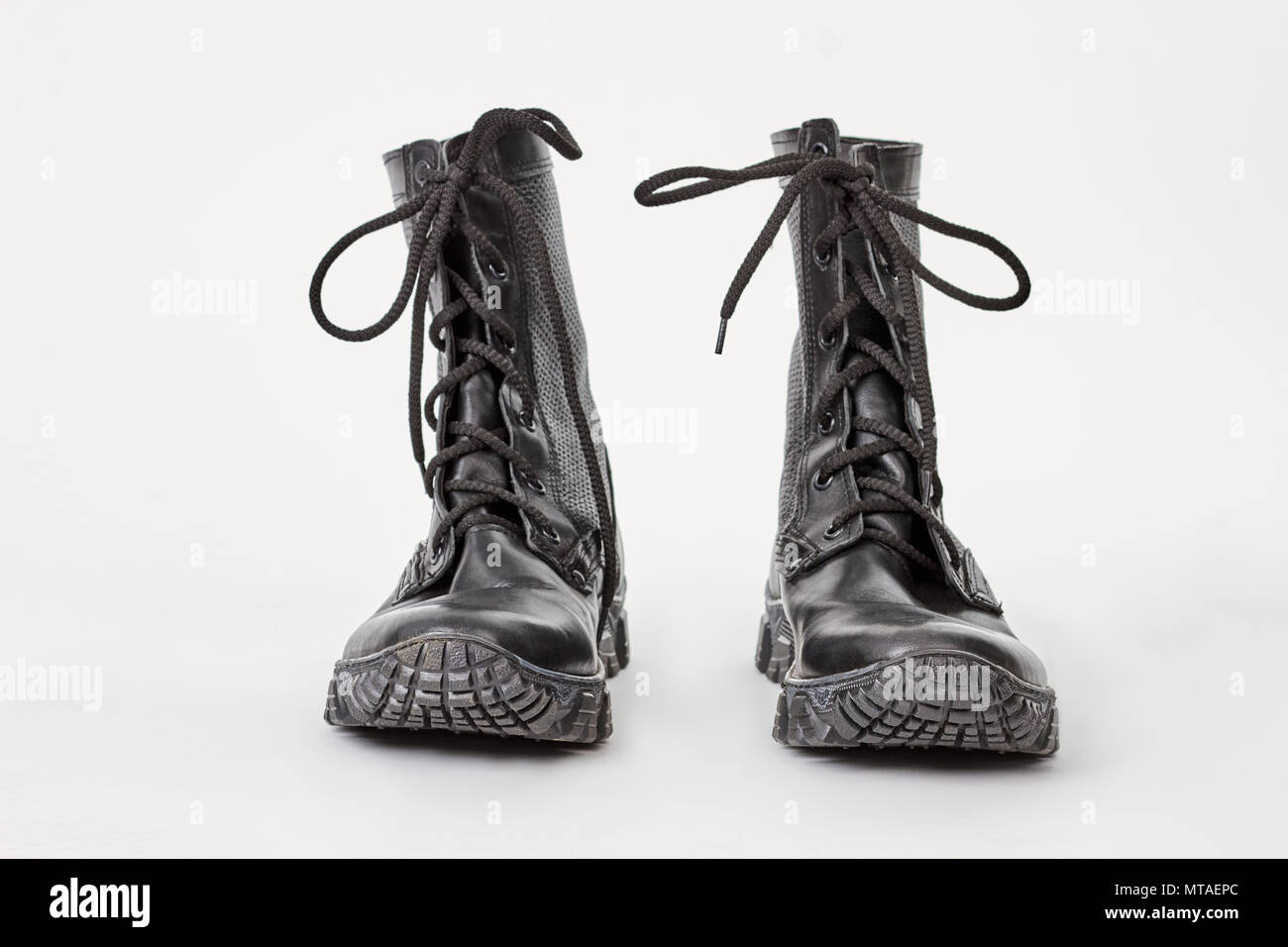 Old combat boots isolated over white. Pair of black military style leather  boots, isolated, front view Stock Photo - Alamy