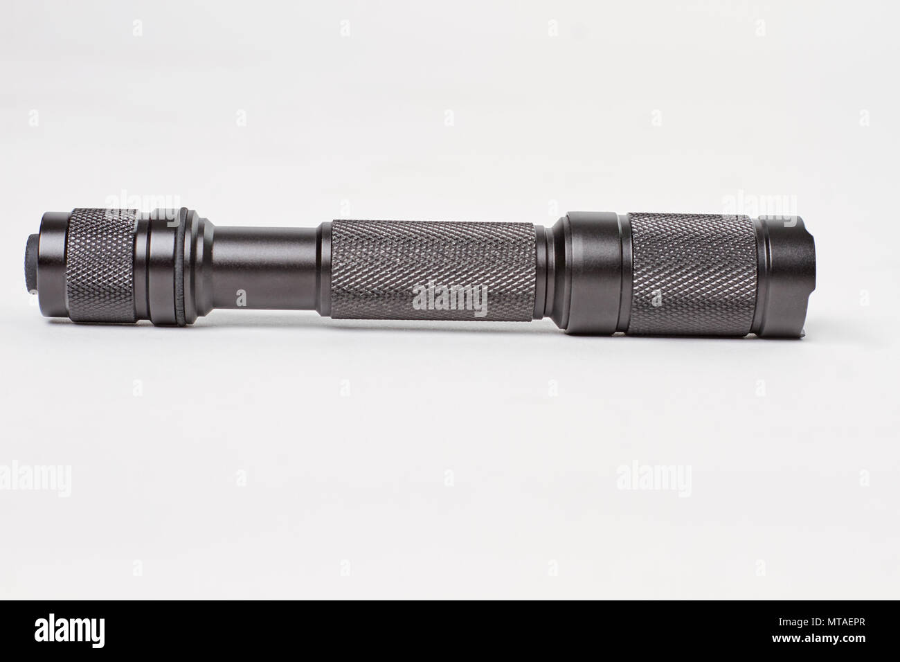 Black military flashlight close up. White isolated background Stock ...