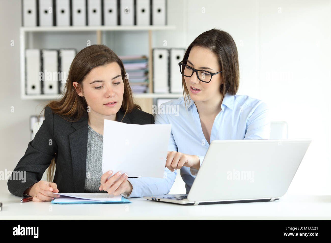 Two concentrated office workers coworking comparing documents Stock Photo