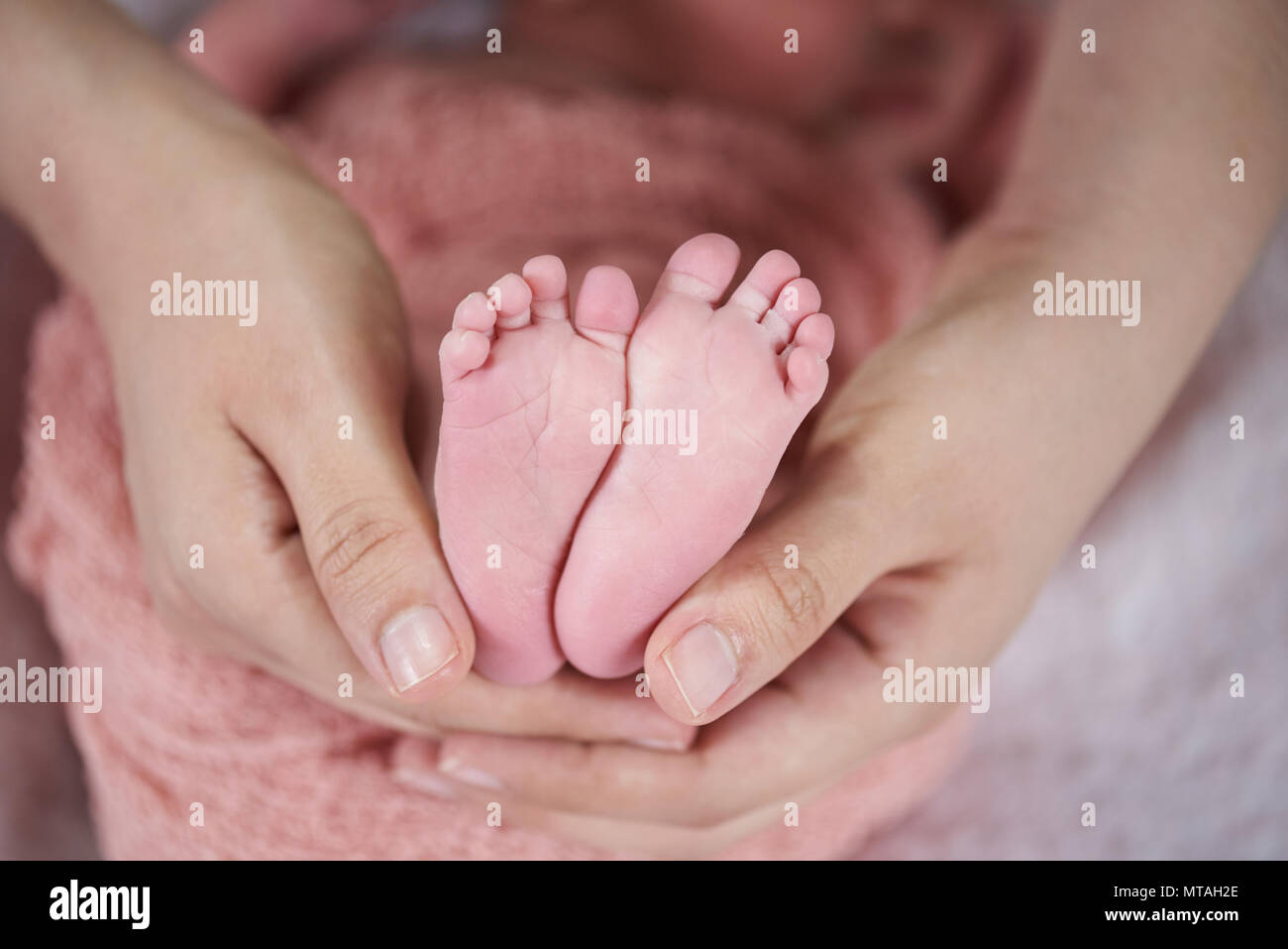 Cute liitle toes of baby in parents hands Stock Photo