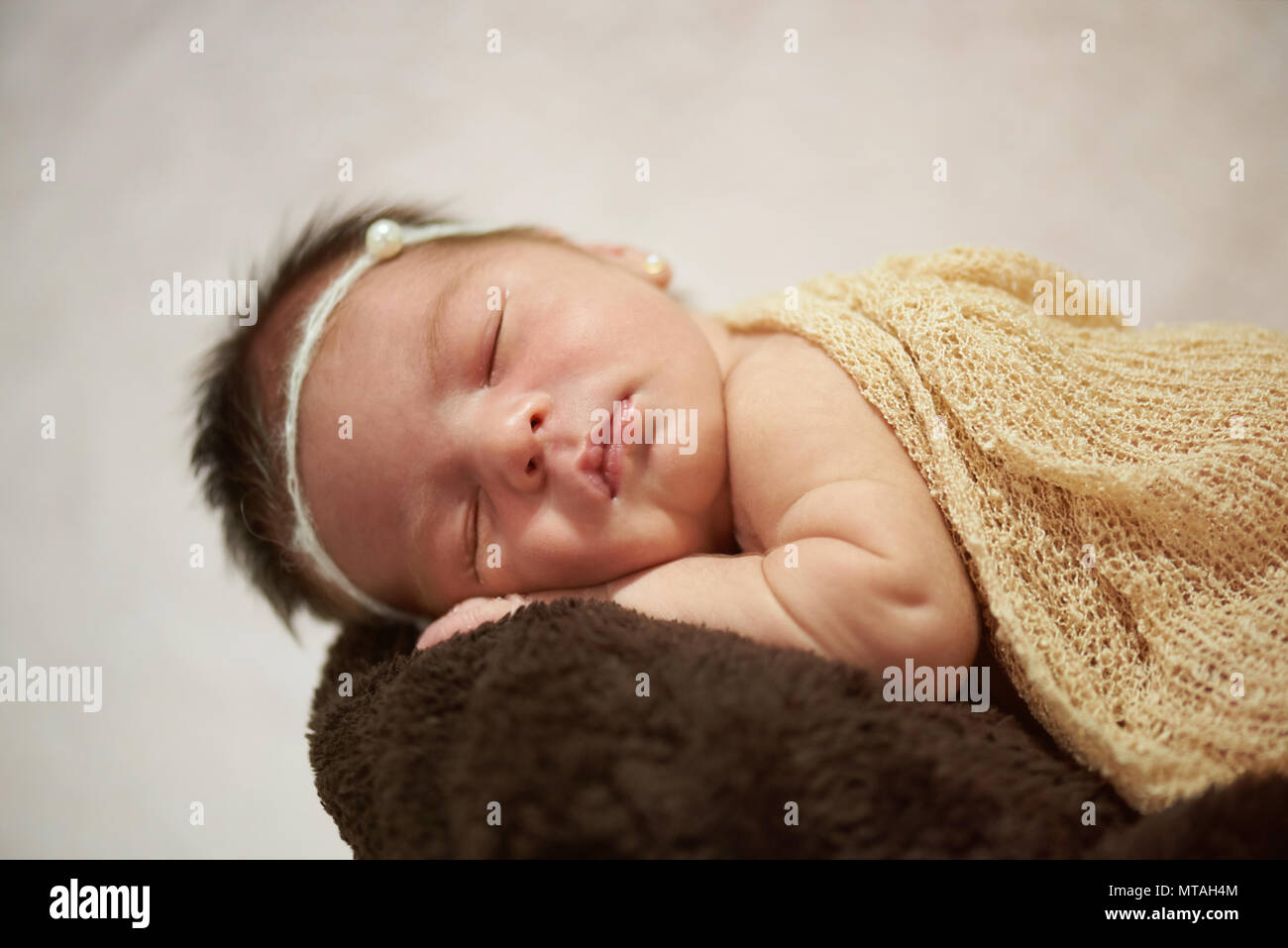 Newborn baby taking nap close up view on bright background Stock Photo