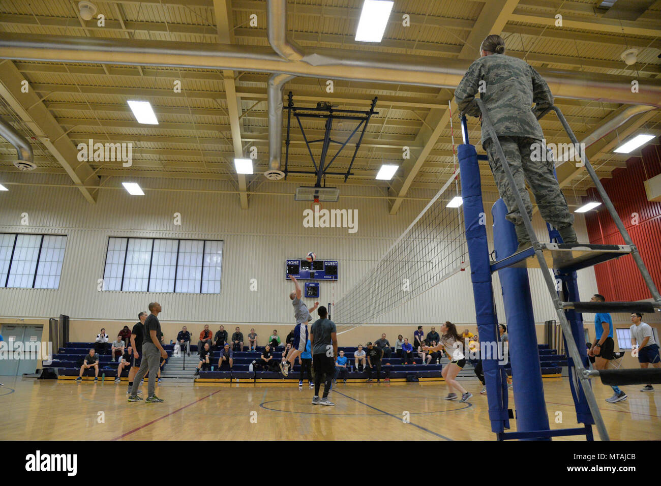 Teams compete during a volleyball game at the base fitness center