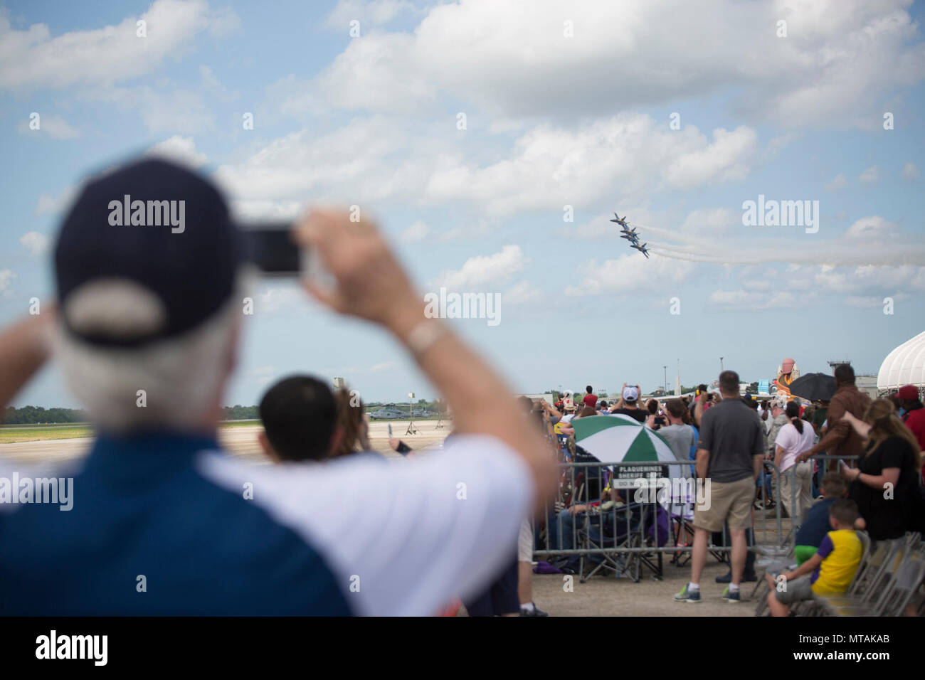 BELLE CHASSE, La. – Spectators at the 2017 New Orleans Air Show watches the Blue Angels perform aerial acrobatics during the New Orleans Air Show 2017 at Naval Air Station Joint Service Base New Orleans, April 21, 2017.  The show included several demonstration teams, Air Show Announcer Rob Reider, and parachute teams. Stock Photo