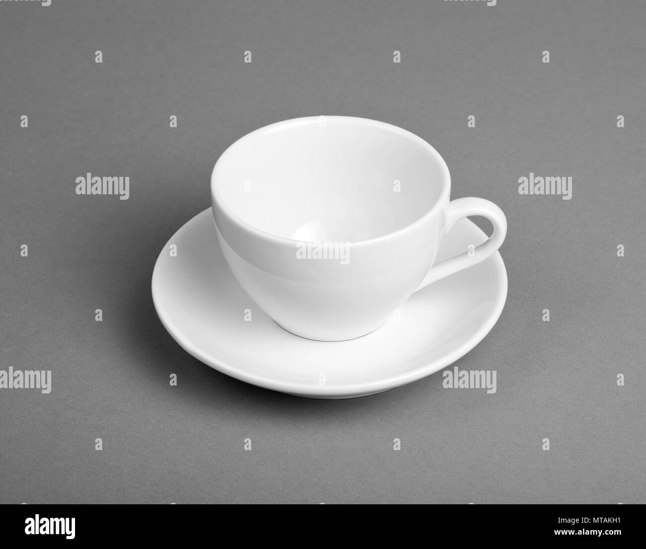 White mug and saucer on a gray background Stock Photo