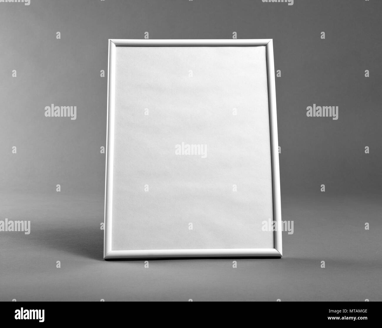 White vertical frame for paintings or photographs on gray background
