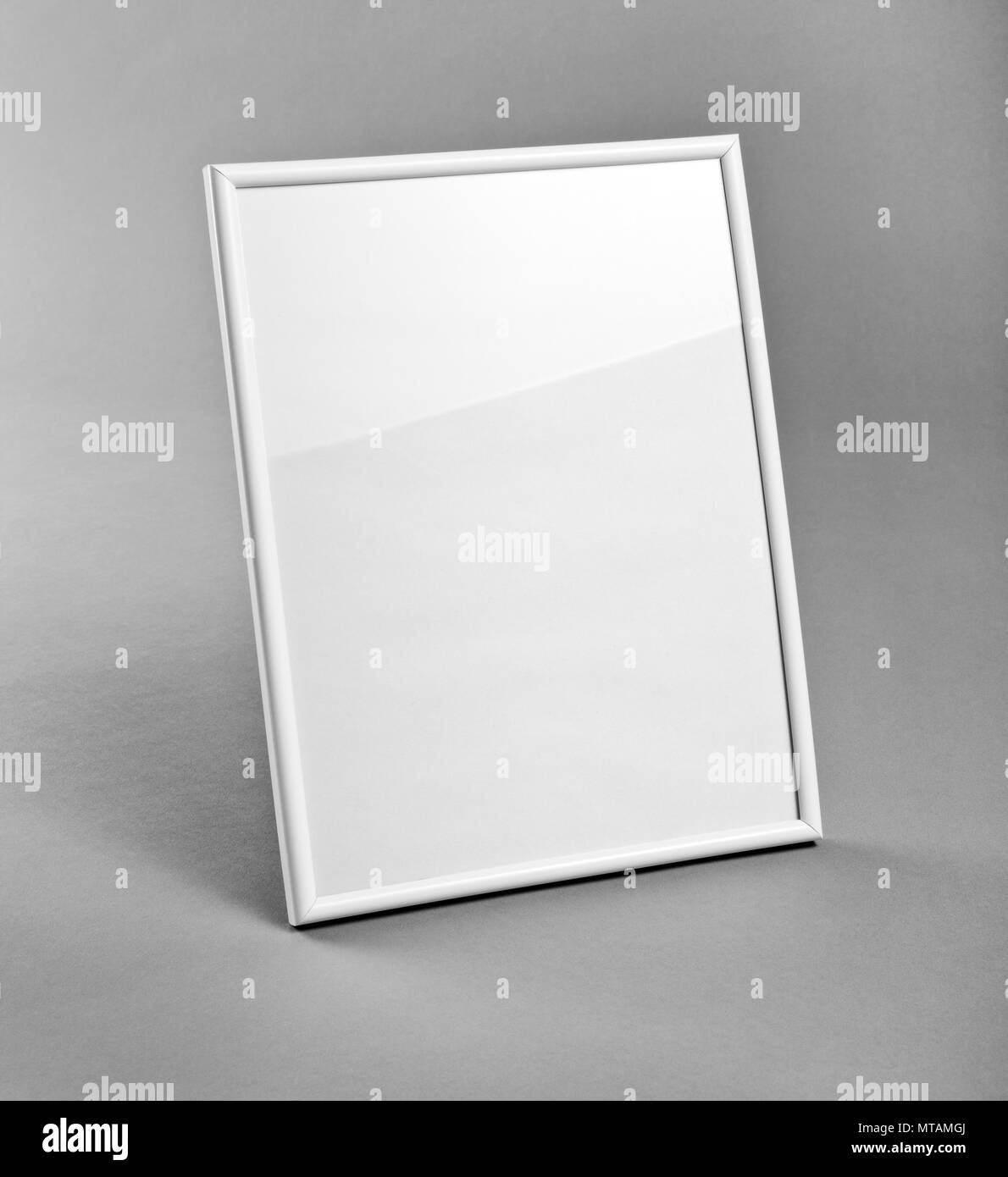 White vertical frame for paintings or photographs on gray background
