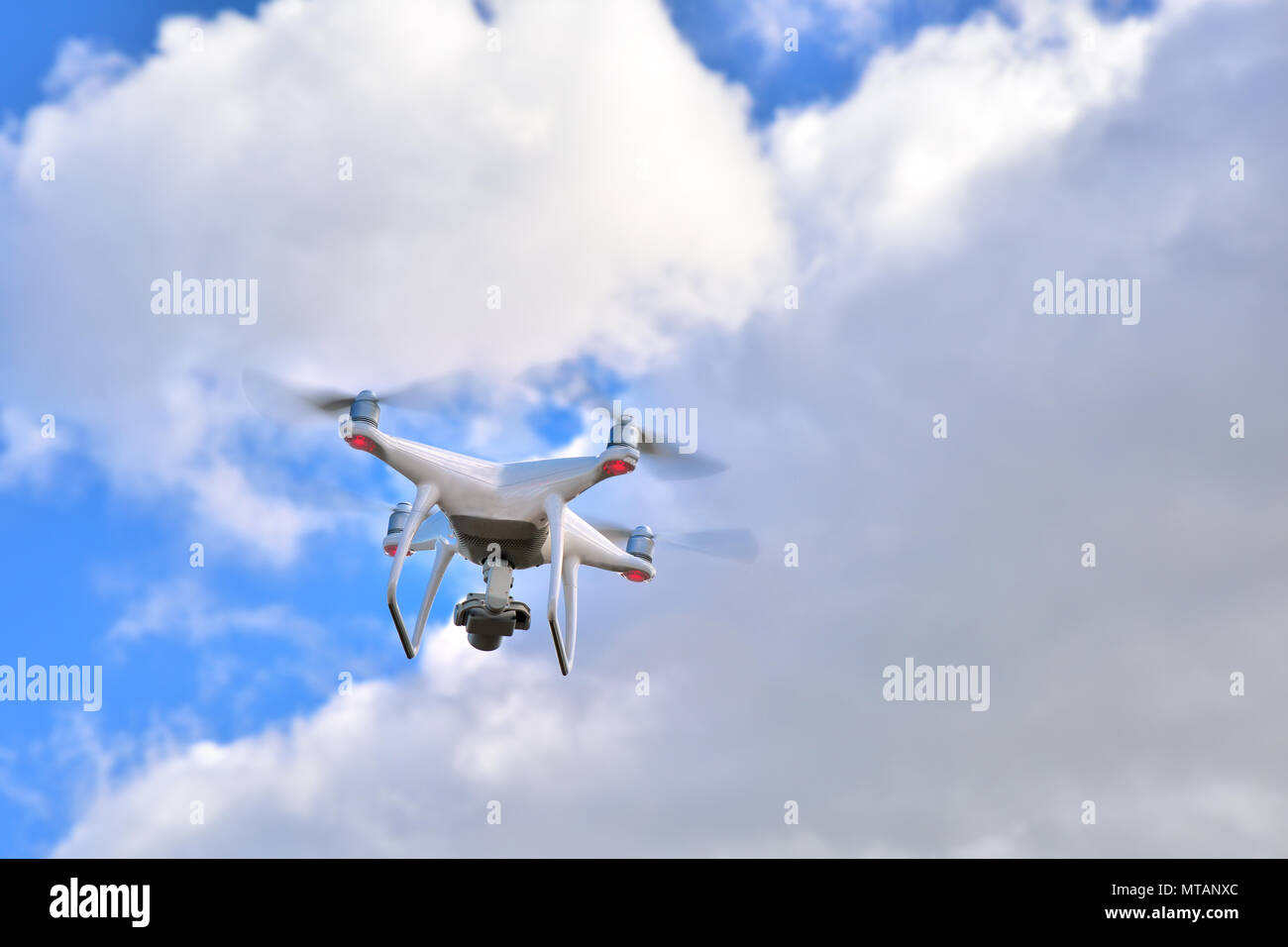 Professional drone with camera for photo and video recording flying with sky with clouds in the background Stock Photo
