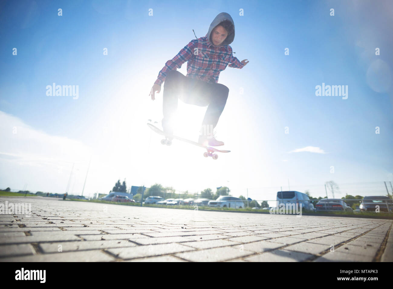 Skateboarder makes jump trick on board against sunset Stock Photo Alamy