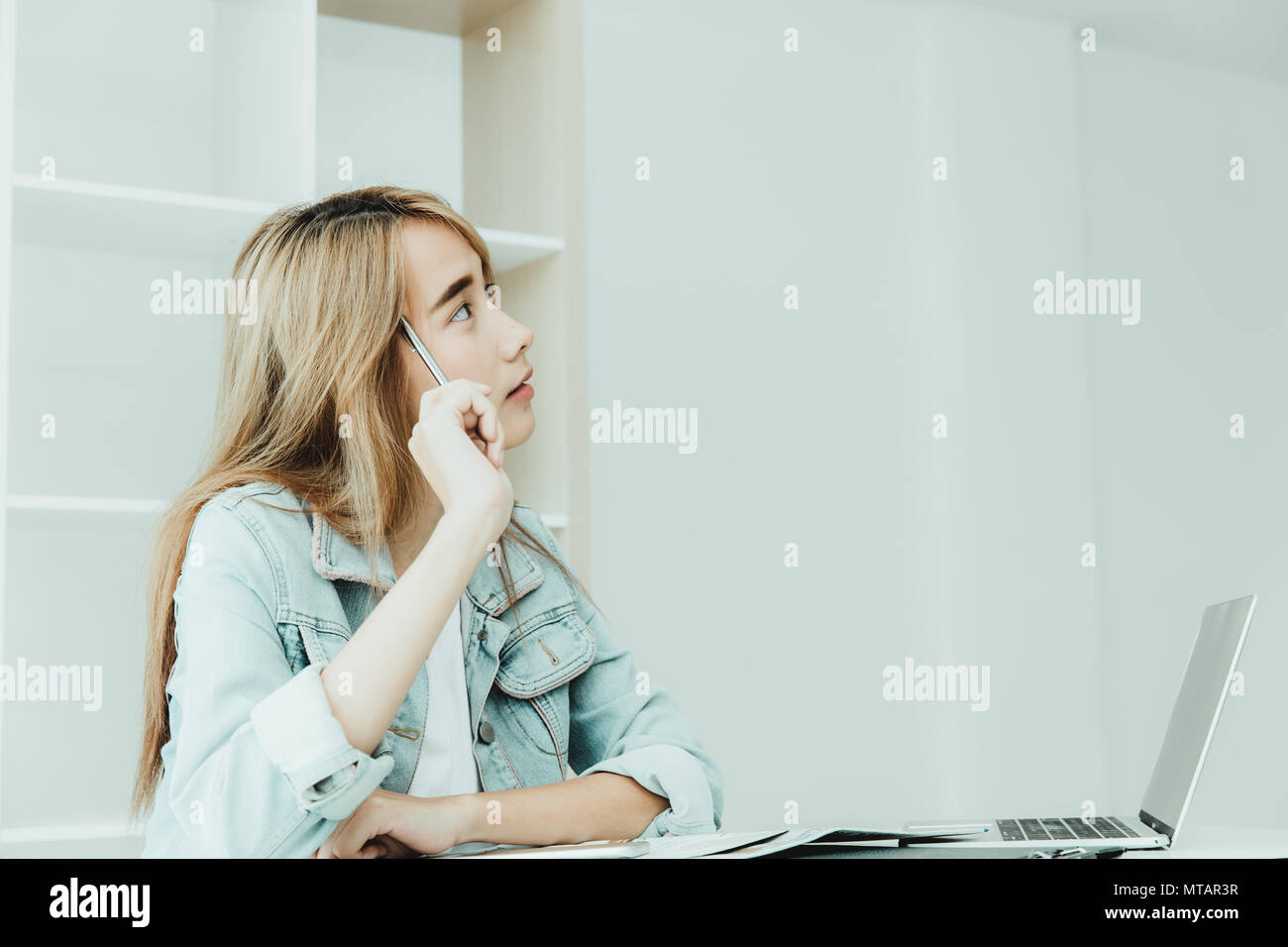 Asian young employee thinking or inattentive imagination dream while working in the office vintage tone Stock Photo