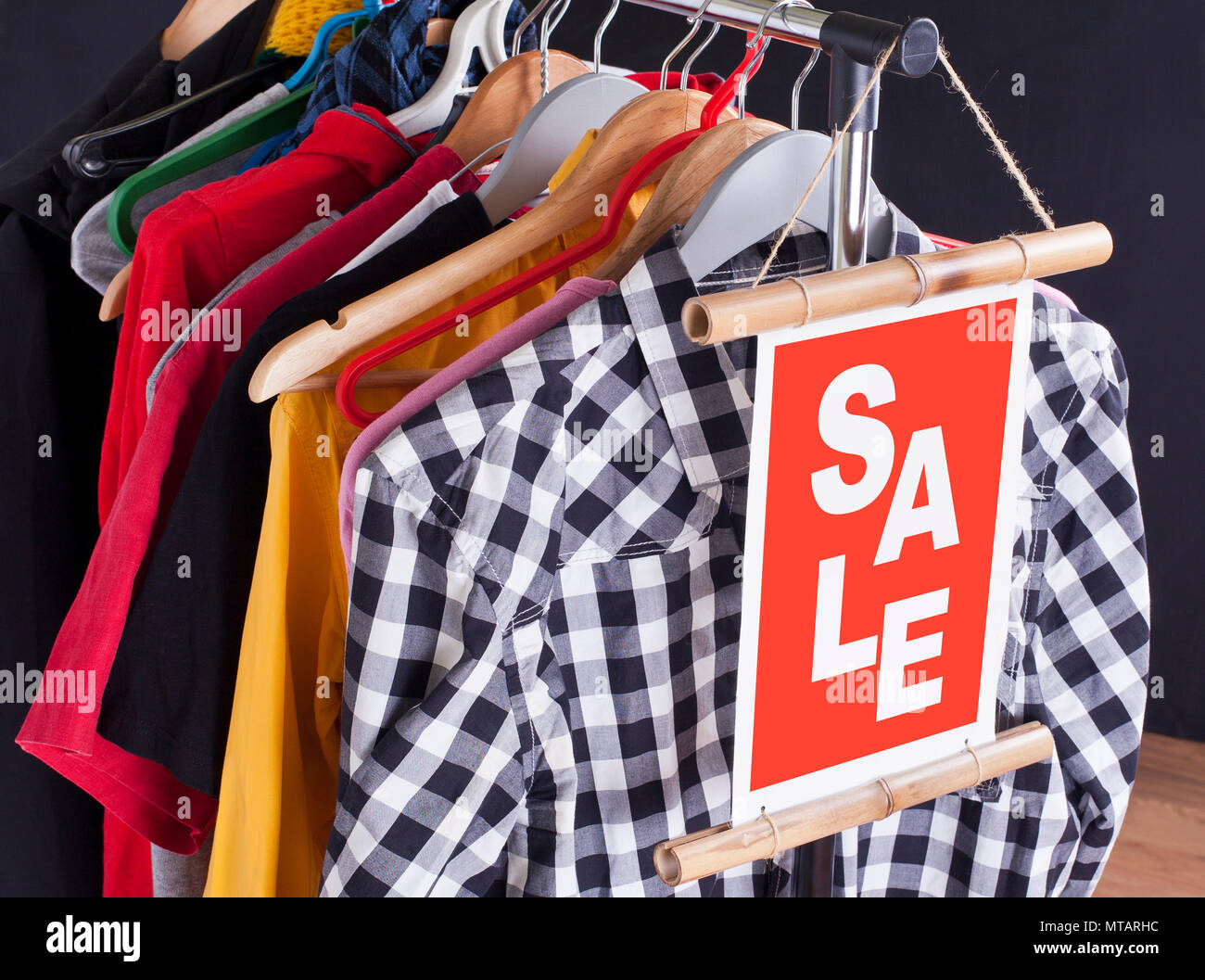 Sale in a clothing store - discount sign at a clothes rack Stock Photo