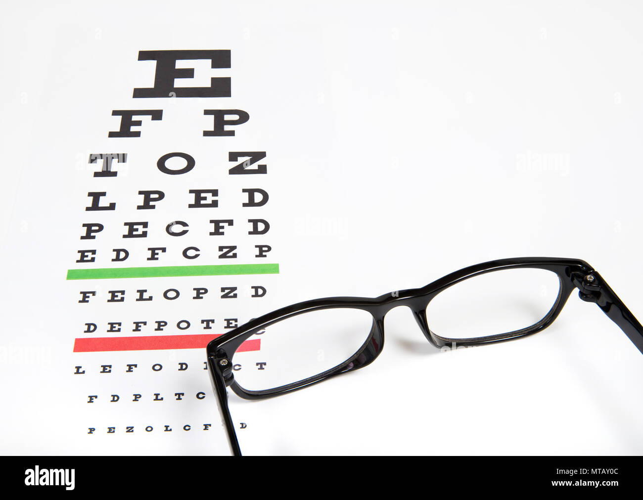 Eye glasses on eyesight test chart background close up. Stock Photo