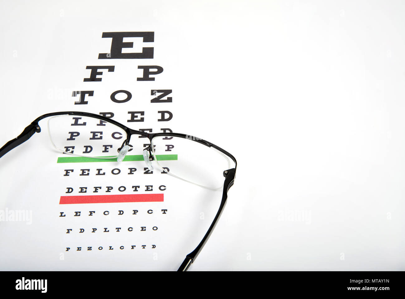 Eye glasses on eyesight test chart background close up. Stock Photo